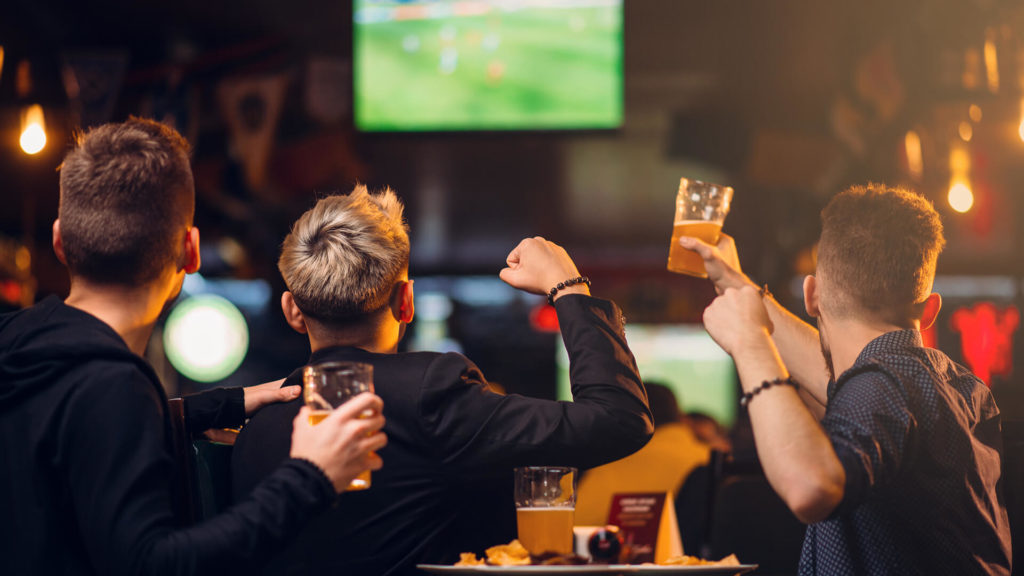 JCLM Solicitors Men watching sport in bar with beer.